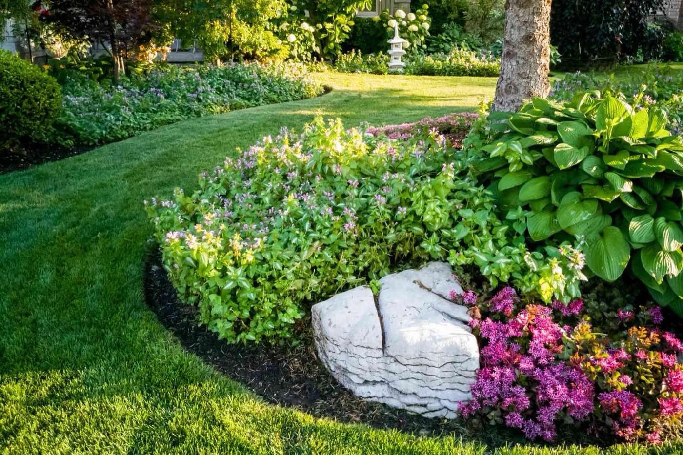 Lawn and planting bed with a carved stone accent
