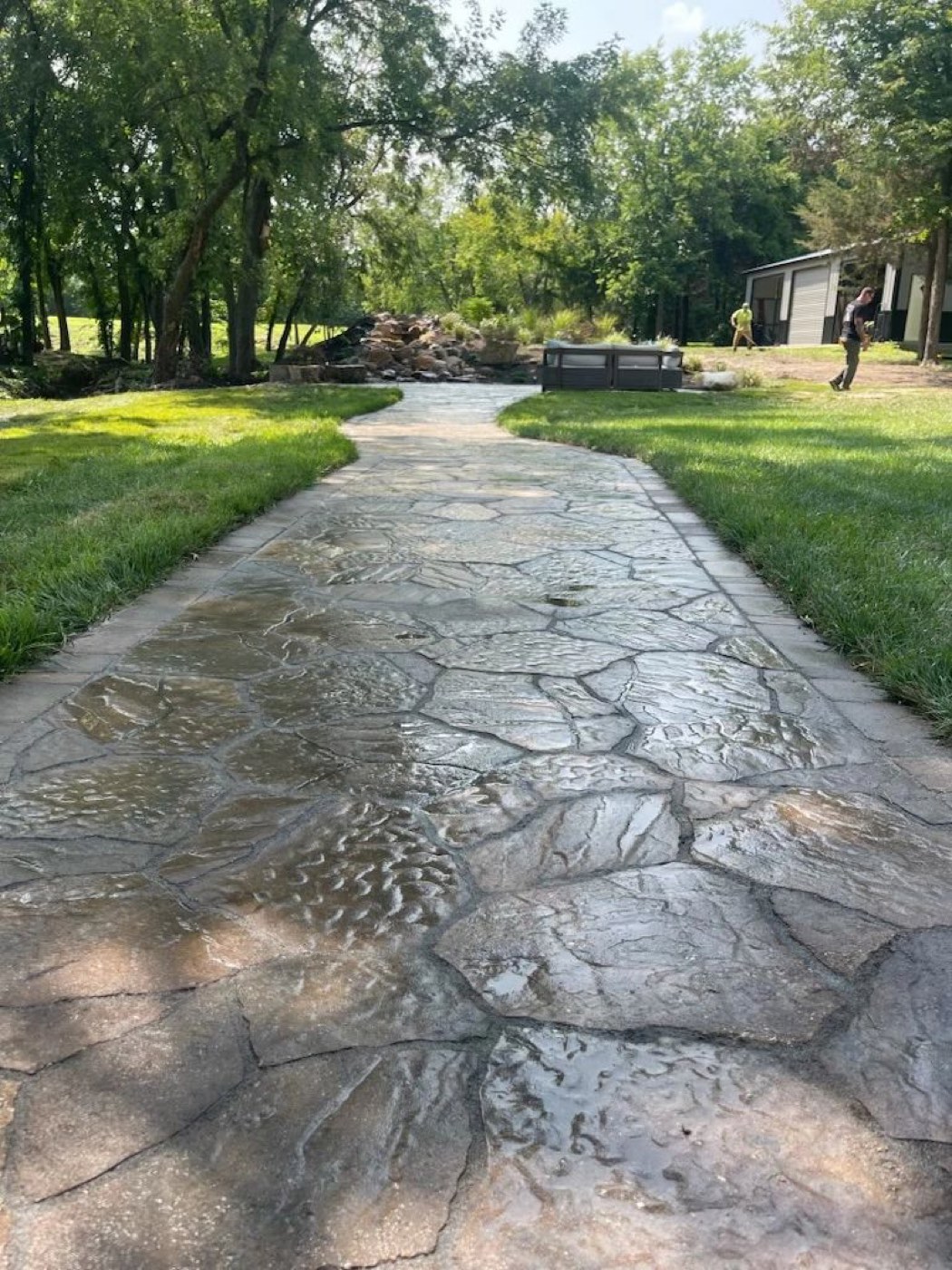 Long stamped walkway across a backyard