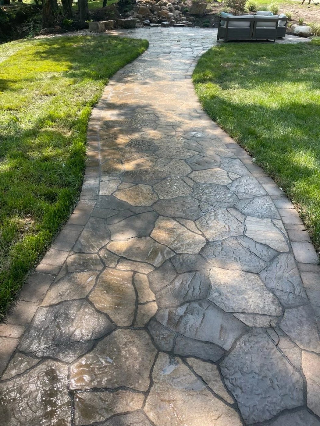 Curved stamped walkway through a green lawn
